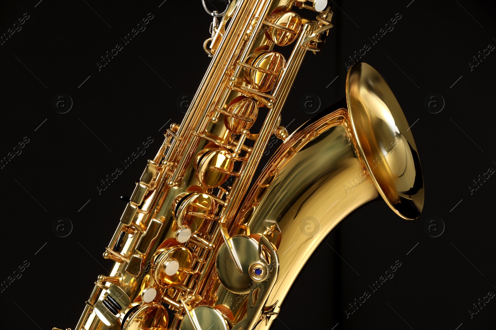 Photo of Jazz. One beautiful saxophone on black background, closeup