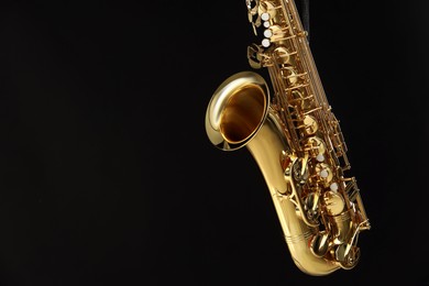 Photo of Jazz. One beautiful saxophone on black background, space for text