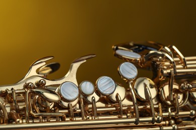 Photo of Jazz. One beautiful saxophone on color background, closeup