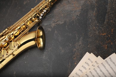 Photo of Jazz. Saxophone and musical notes on black textured table, top view. Space for text