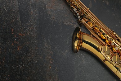 Photo of Jazz. One saxophone on black textured table, top view. Space for text