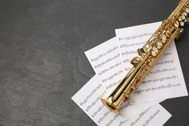 Photo of Jazz. Saxophone and music notes on black table, top view. Space for text