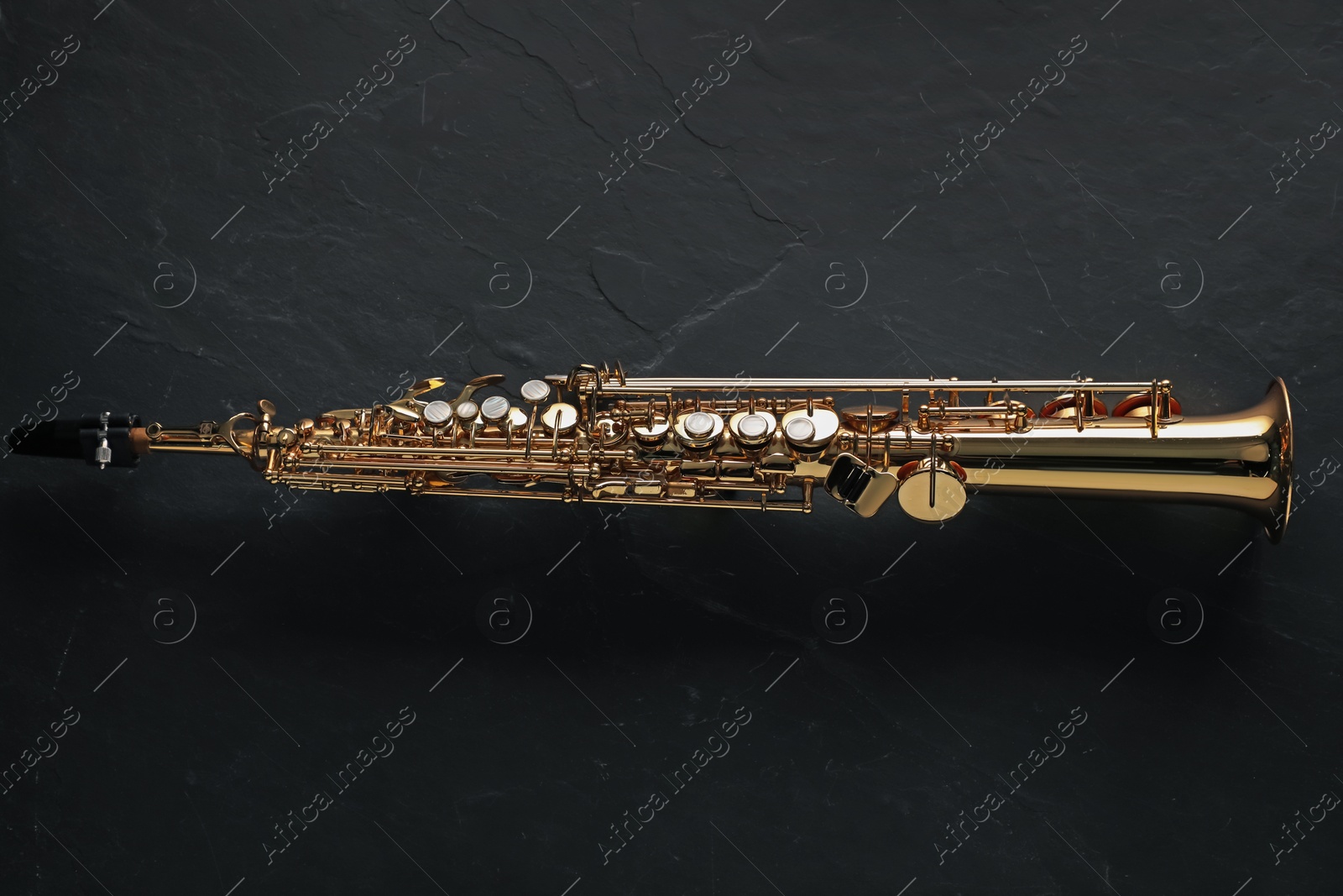 Photo of Jazz. One saxophone on black table, top view