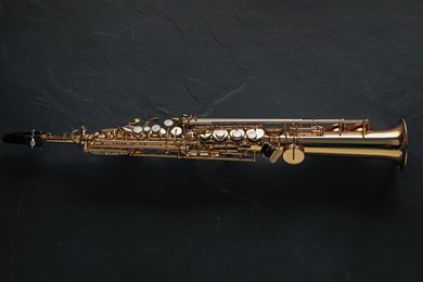 Photo of Jazz. One saxophone on black table, top view