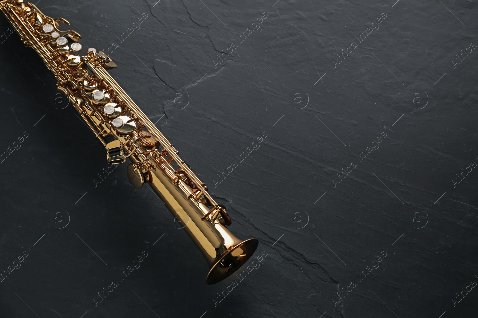 Photo of Jazz. One saxophone on black table, top view. Space for text