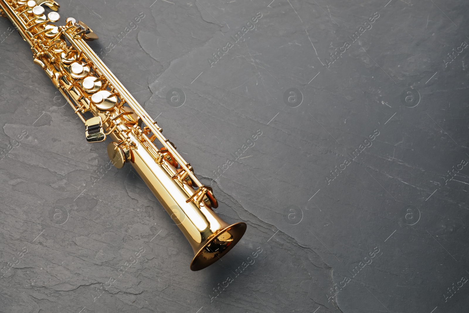 Photo of Jazz. One saxophone on black table, top view. Space for text