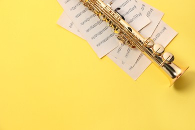 Photo of Jazz. Saxophone and musical notes on yellow background, top view. Space for text