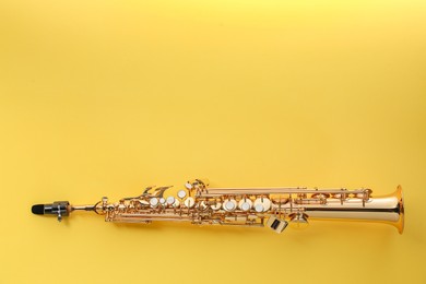 Photo of Jazz. One saxophone on yellow background, top view. Space for text