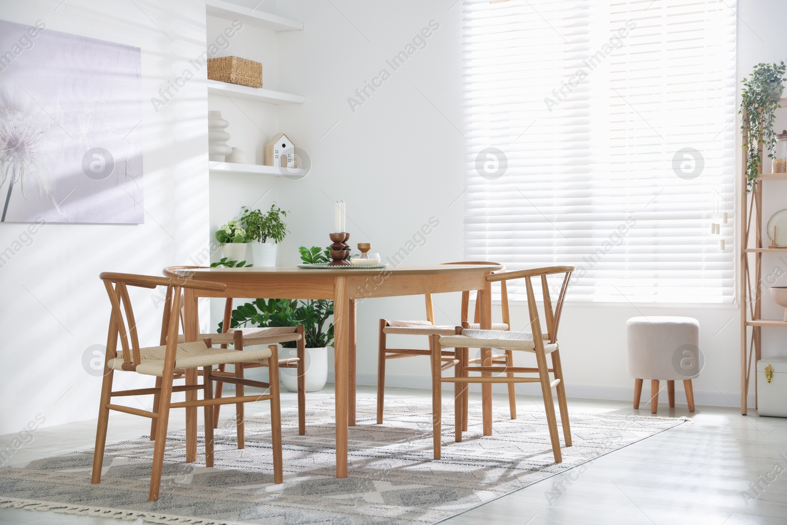 Photo of Stylish room with wooden table, chairs and houseplants. Interior design