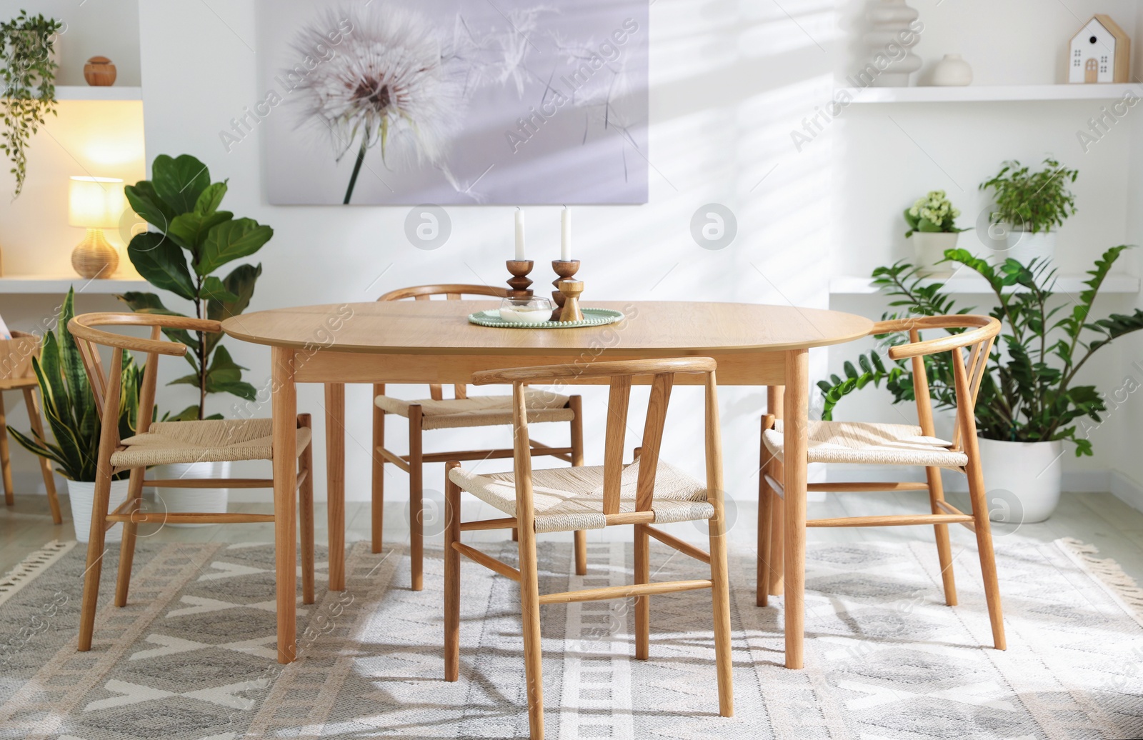 Photo of Stylish room with wooden table, chairs and houseplants. Interior design