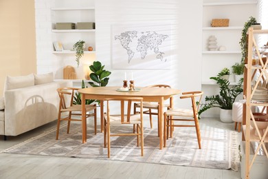 Photo of Stylish wooden table with chairs and decor indoors. Interior design