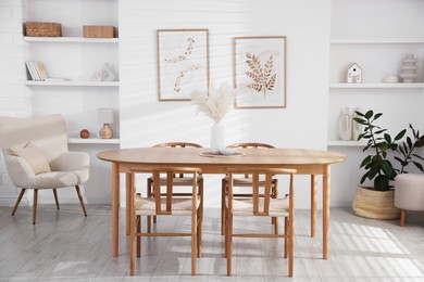 Photo of Stylish wooden table with chairs and decor indoors. Interior design