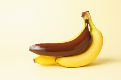 Photo of Stop racism. Bunch of yellow bananas with dark one on beige background