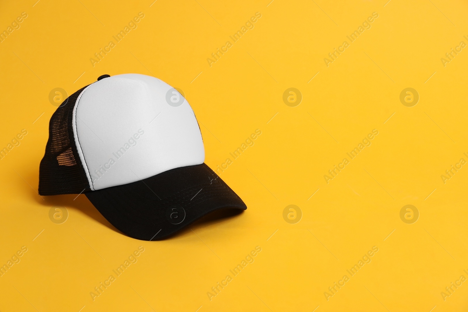 Photo of Blank baseball cap for branding on orange background. Mockup for design