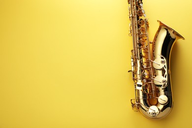 Photo of Jazz. One saxophone on yellow background, top view. Space for text