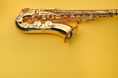 Photo of Jazz. One saxophone on yellow background, top view. Space for text