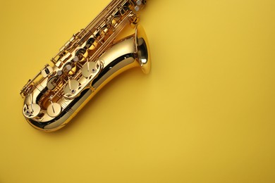 Photo of Jazz. One saxophone on yellow background, top view. Space for text