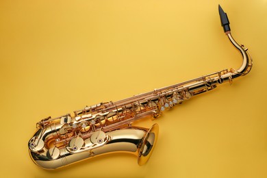 Photo of Jazz. One saxophone on yellow background, top view. Space for text