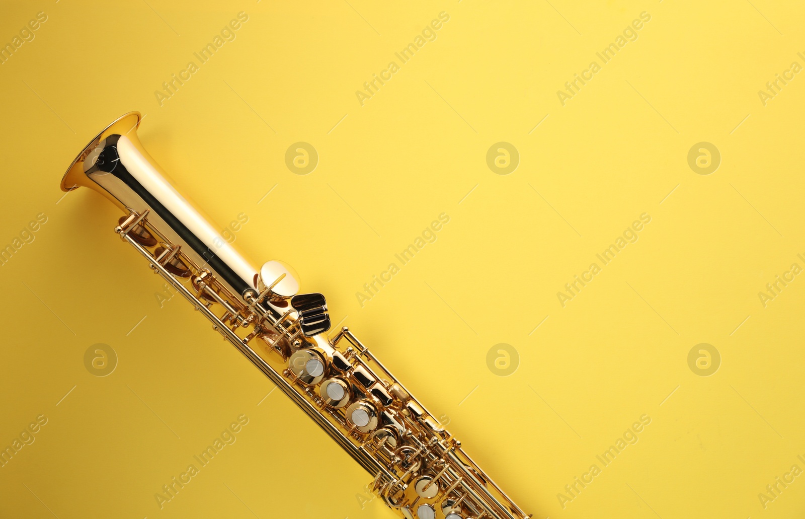 Photo of Jazz. One saxophone on yellow background, top view. Space for text