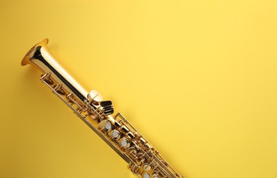 Photo of Jazz. One saxophone on yellow background, top view. Space for text