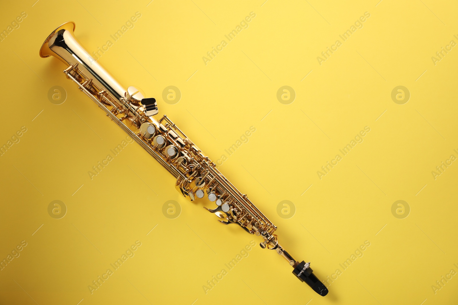 Photo of Jazz. One saxophone on yellow background, top view. Space for text