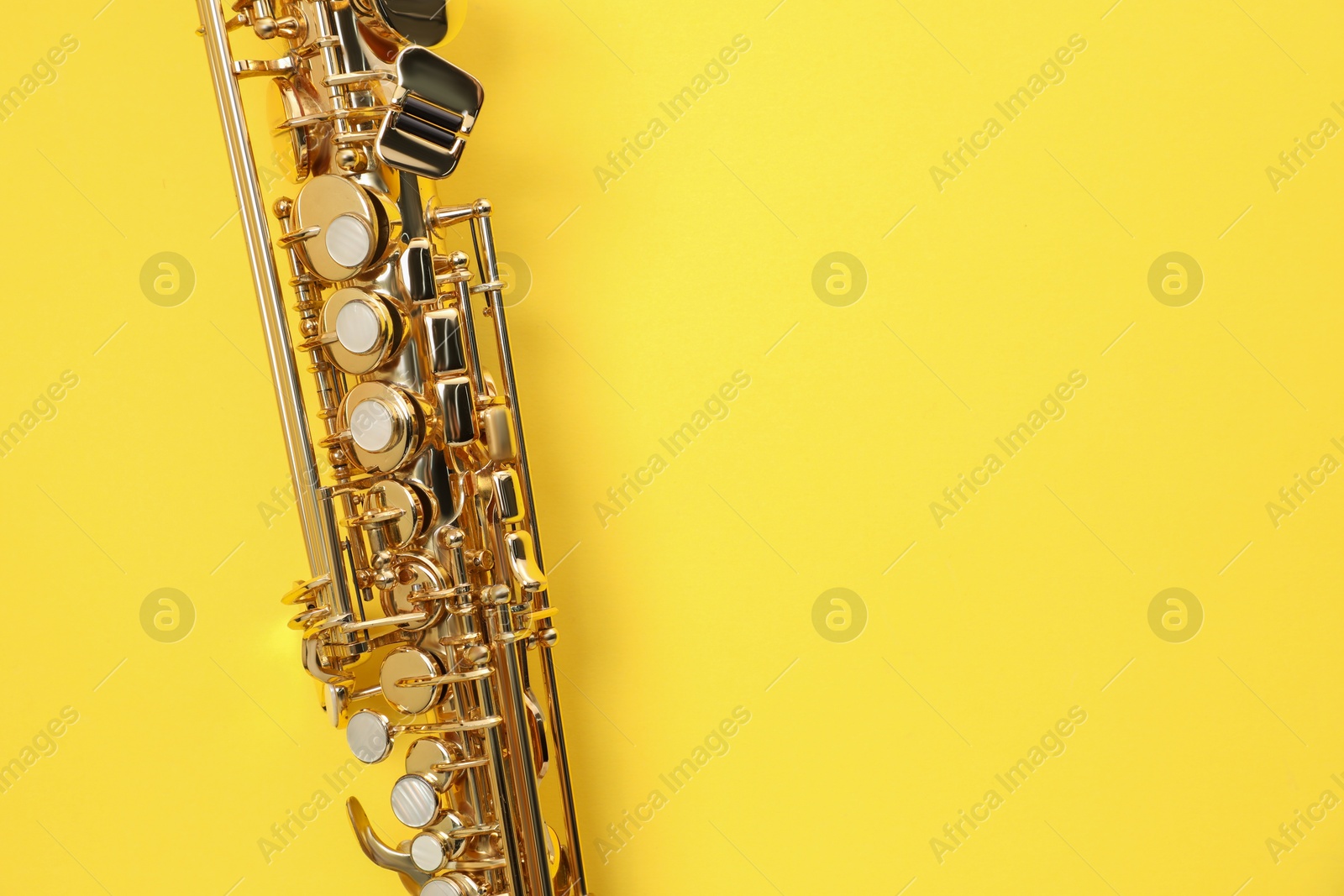 Photo of Jazz. One saxophone on yellow background, top view. Space for text