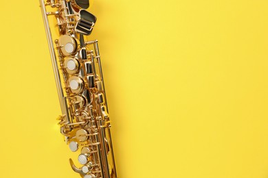 Photo of Jazz. One saxophone on yellow background, top view. Space for text