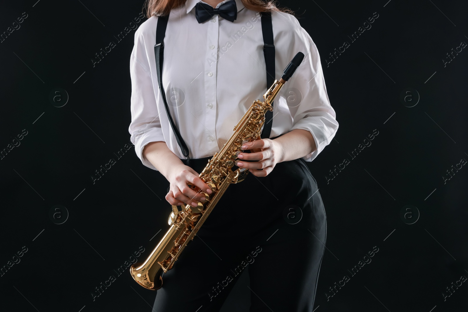 Photo of Musician with soprano saxophone on dark background, closeup