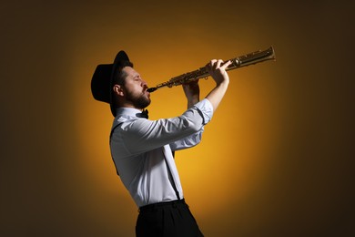 Photo of Professional musician playing soprano saxophone on color background