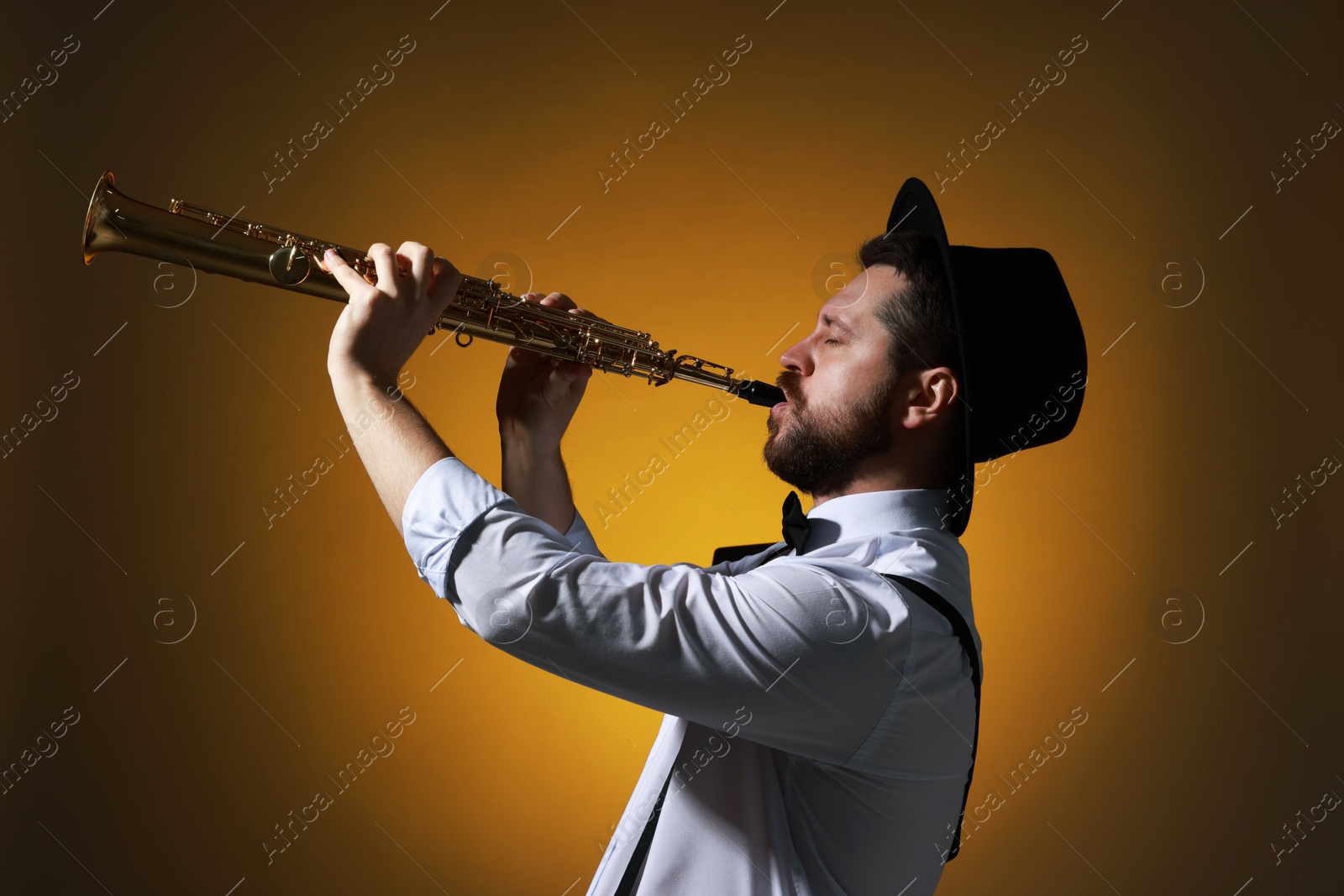 Photo of Professional musician playing soprano saxophone on color background