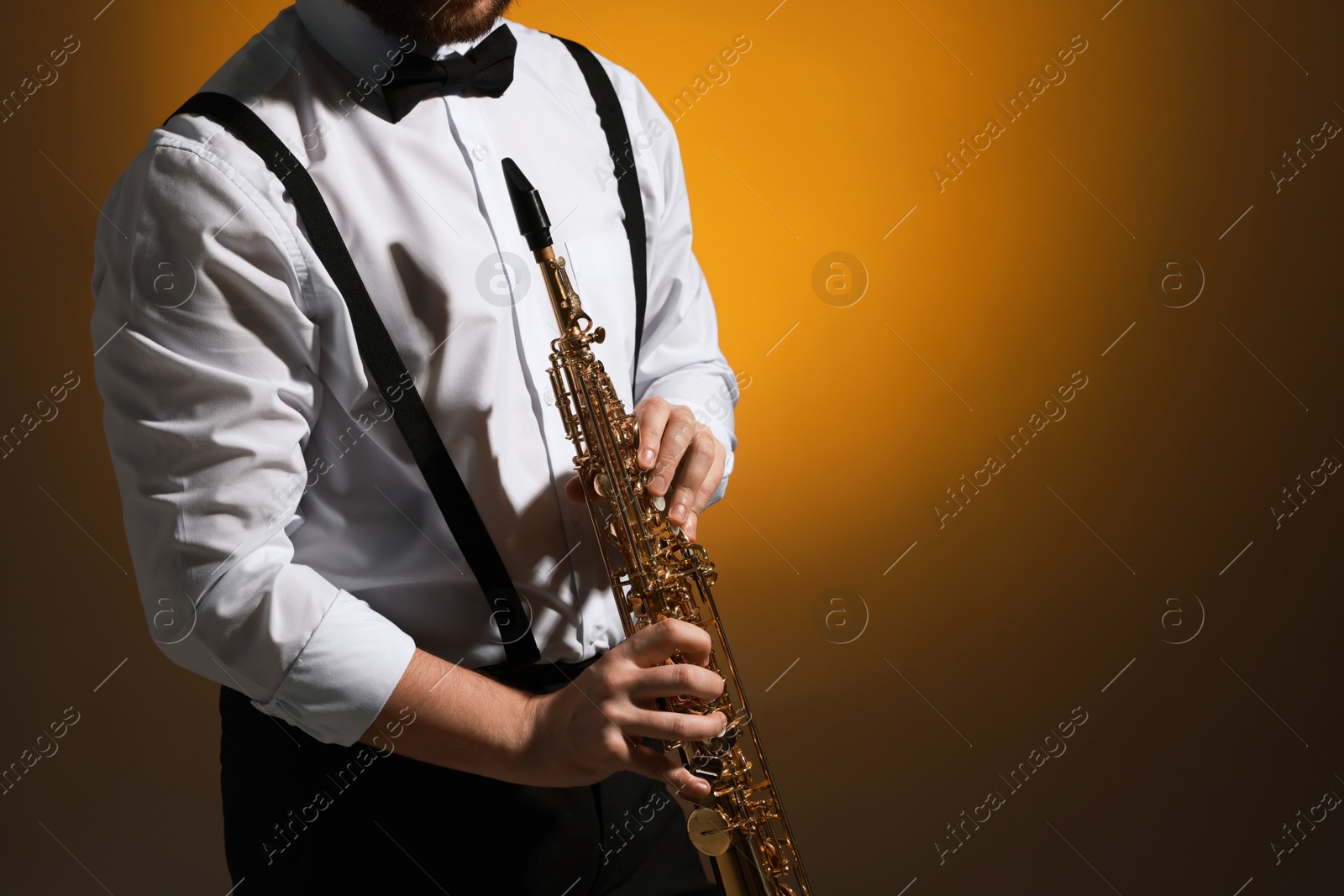 Photo of Professional musician with soprano saxophone on color background, closeup. Space for text