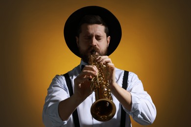 Professional musician playing soprano saxophone on color background