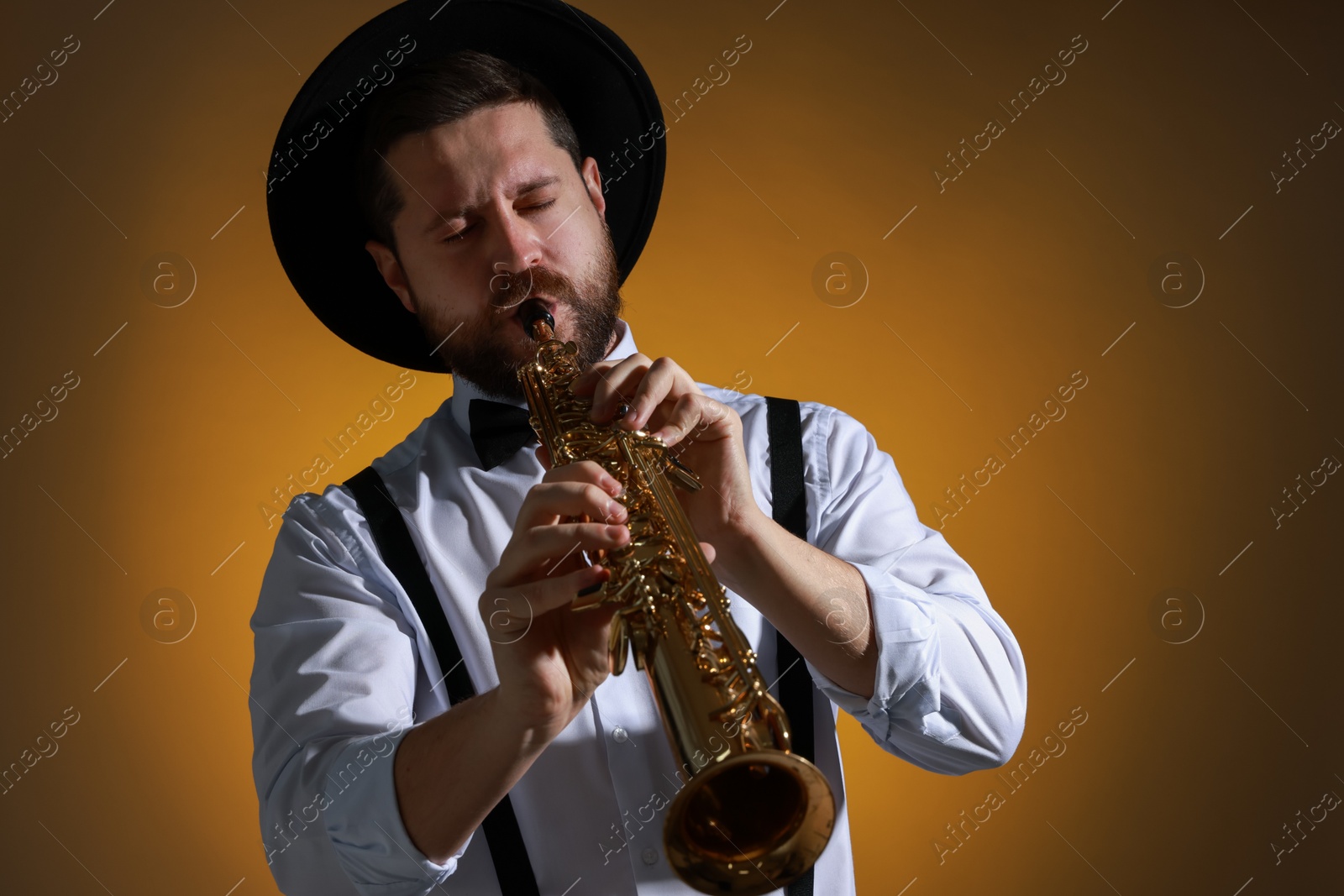 Photo of Professional musician playing soprano saxophone on color background