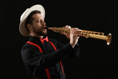 Photo of Professional musician playing soprano saxophone on black background