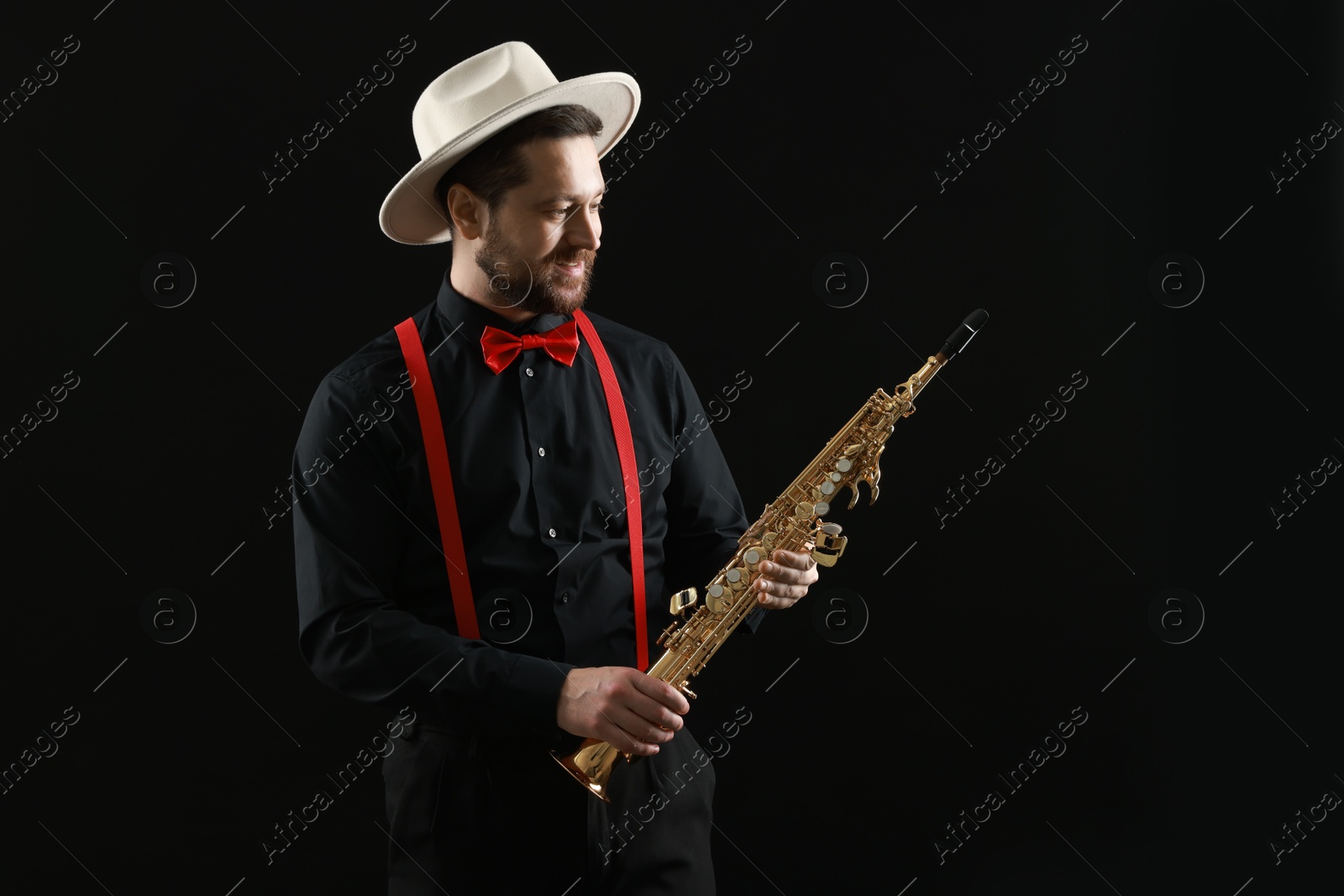 Photo of Professional musician with soprano saxophone on black background