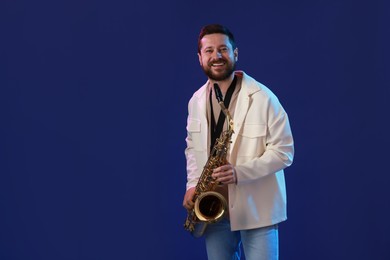 Photo of Professional musician with saxophone on blue background