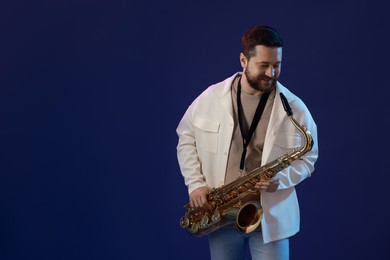 Professional musician with saxophone on blue background. Space for text