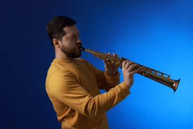 Photo of Professional musician playing soprano saxophone on blue background