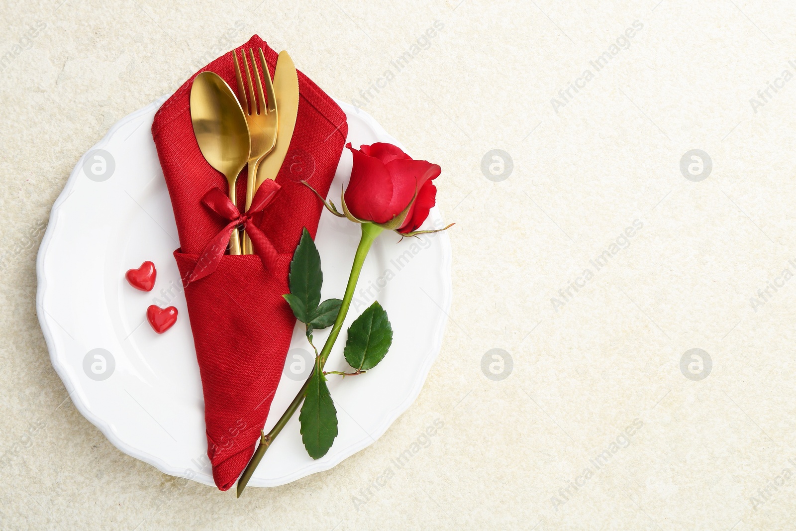 Photo of Romantic place setting with red rose on white table, top view. Valentine's day celebration