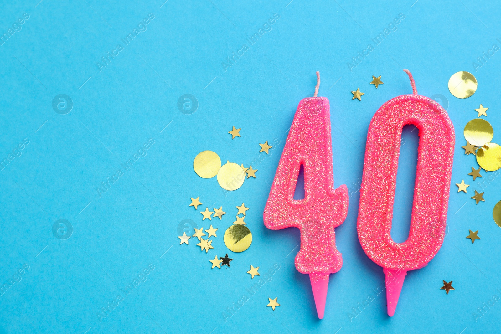 Photo of 40th birthday. Number shaped candles and confetti on light blue background, flat lay. Space for text