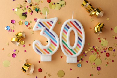 Photo of 30th birthday. Number shaped candles and confetti on beige background, flat lay