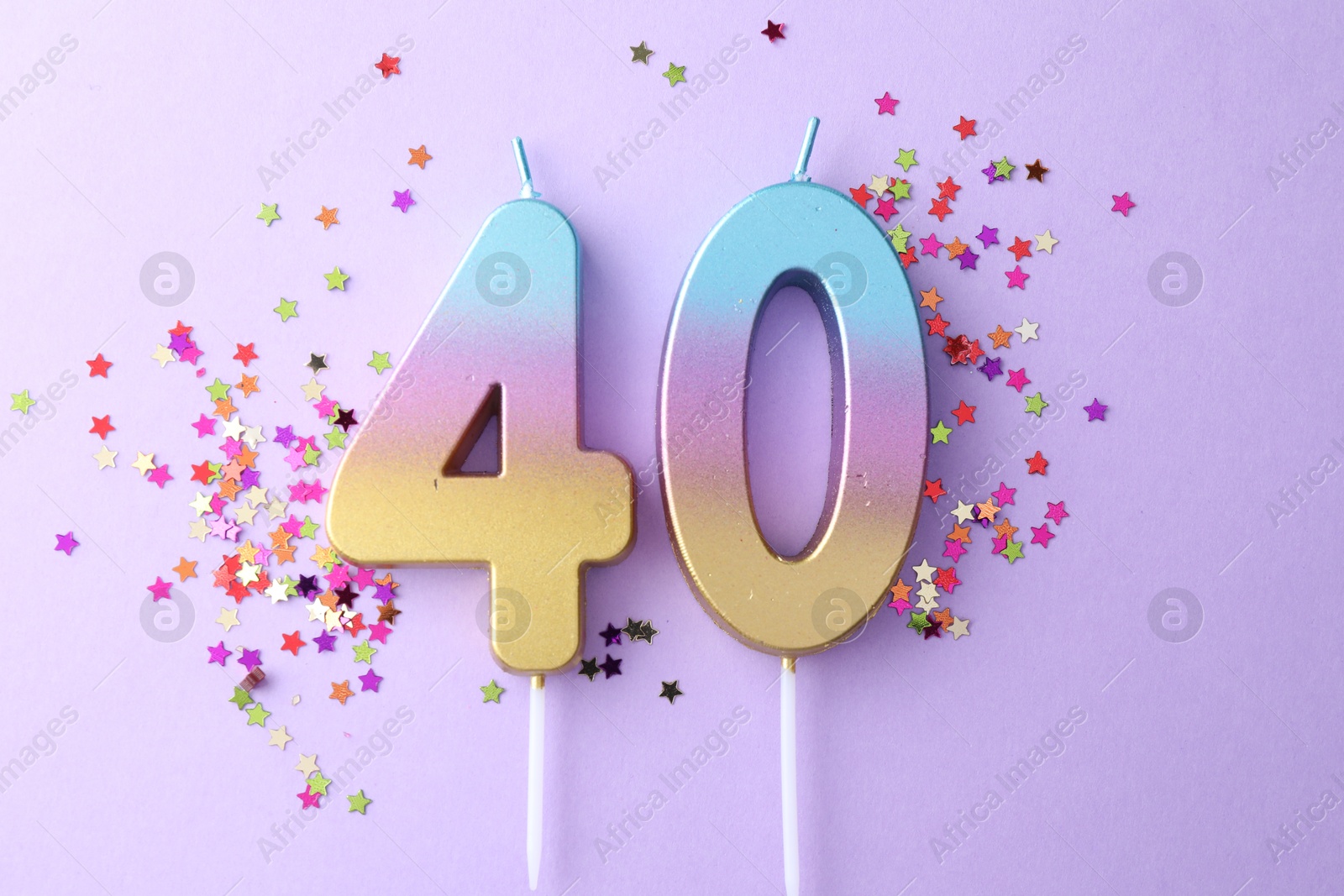 Photo of 40th birthday. Number shaped candles and confetti on violet background, flat lay