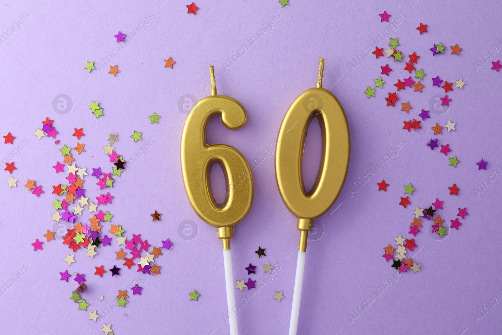 Photo of 60th birthday. Number shaped candles and confetti on violet background, flat lay