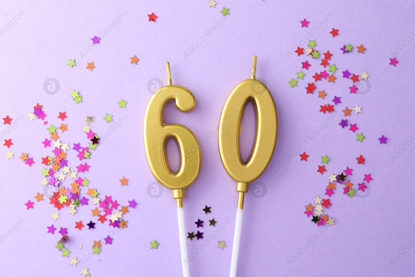 Photo of 60th birthday. Number shaped candles and confetti on violet background, flat lay