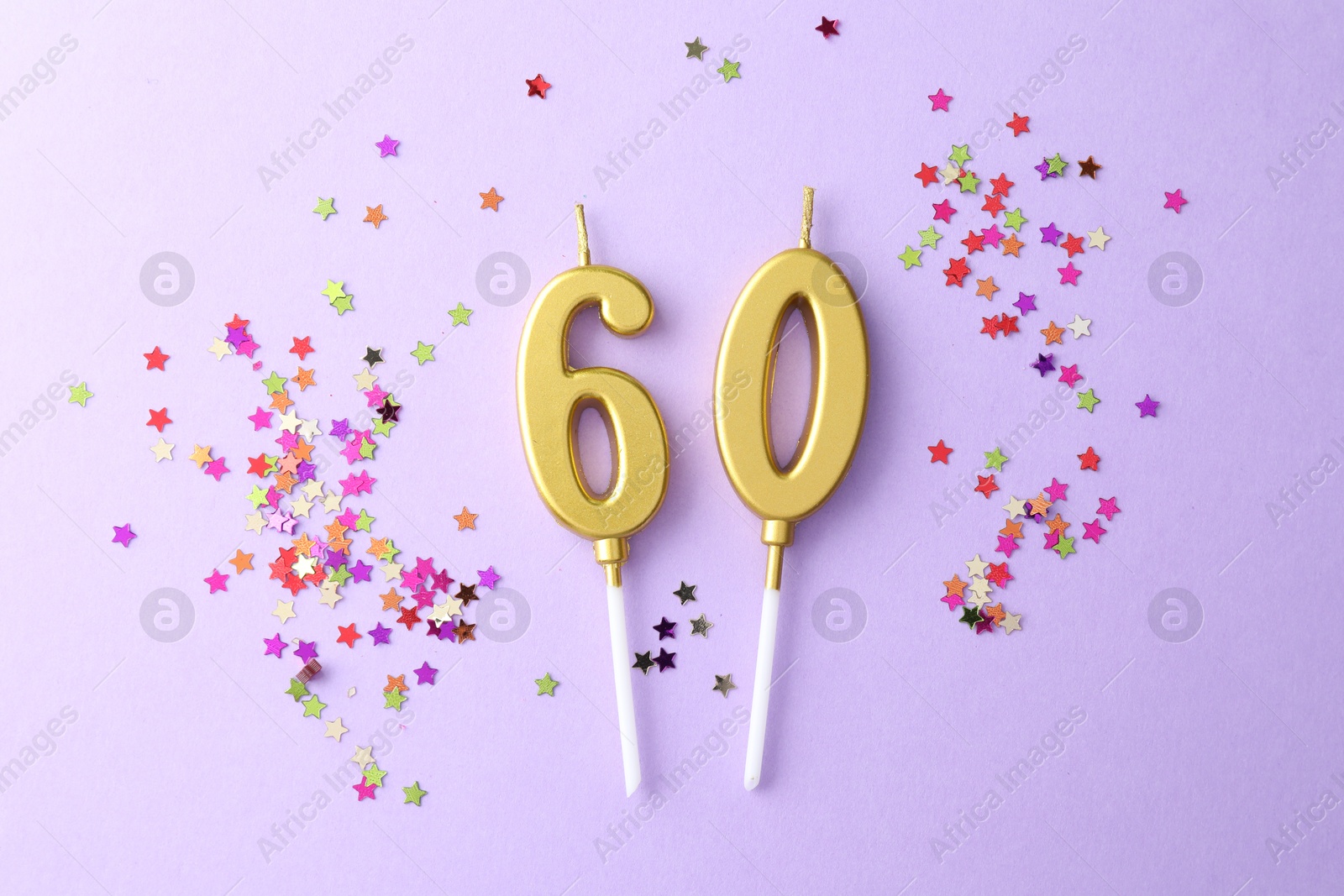 Photo of 60th birthday. Number shaped candles and confetti on violet background, flat lay