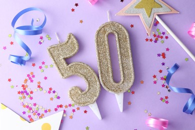 Photo of 50th birthday. Number shaped candles, confetti and party decor on violet background, flat lay