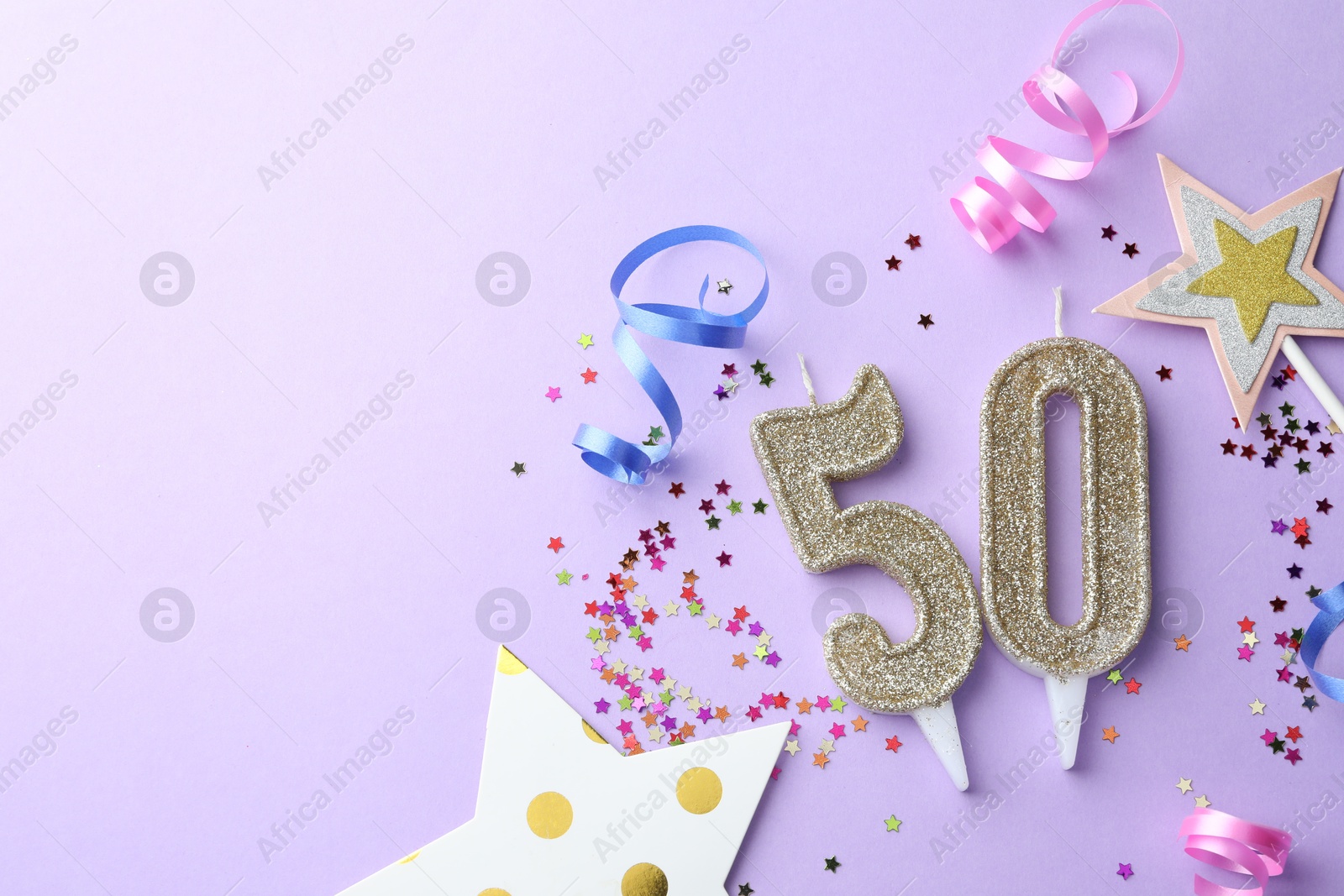 Photo of 50th birthday. Number shaped candles, confetti and party decor on violet background, flat lay. Space for text