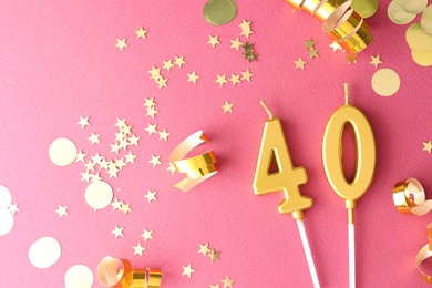 Photo of 40th birthday. Number shaped candles and confetti on pink background, flat lay