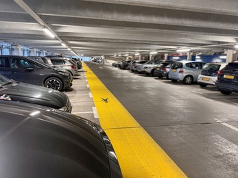 Photo of Many parked cars in underground garage of apartment complex