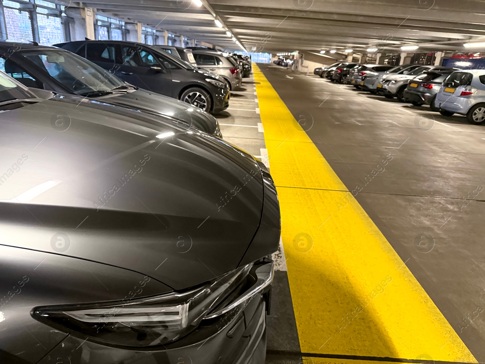 Photo of Many parked cars in underground garage of apartment complex